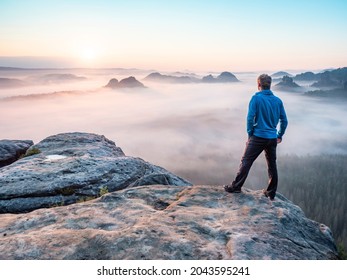 Lone man hiker relaxing on the mountain and watching sunset over the misty valley - Powered by Shutterstock