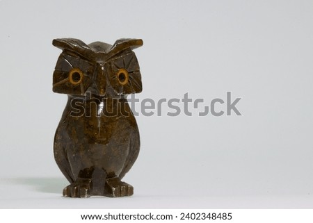 Lone owl carved in stone, on white background and space to put text