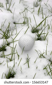 a lone single golf ball in the snow covered grass in Ireland at winter