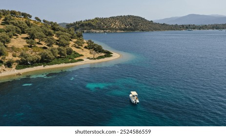 A lone small boat anchored in the tranquil emerald depths with swimmer swimming by in the water - Powered by Shutterstock