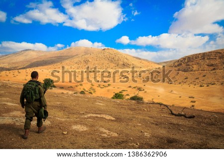 A lone soldier walks through the desert after a long training session
