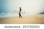 A lone surfer stands on a misty beach, holding his surfboard and looking at the waves. Serene and peaceful scene.