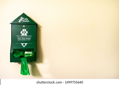 Lone Tree, Colorado, USA - July 21, 2019: Green Fido House Dog Poop Bag Despenser Against the Wall