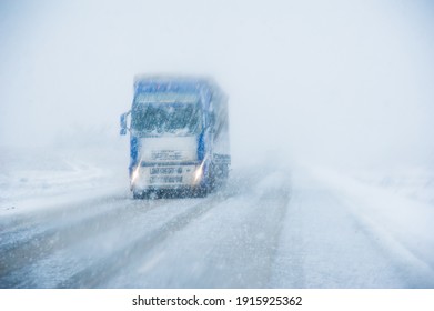 A Lone Truck Driving On A Winter Road In A Snowfall