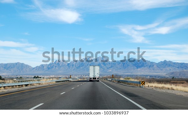 Lone truck\
on the highway with mountain\
background