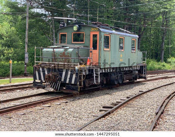 A lone vintage train\
car on the rails