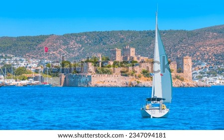 Lone white sail yact near Saint Peter Castle (Bodrum castle) and marina in Bodrum, Turkey