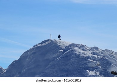 Lone Wolf On The Peak Of Chopok In Low Tatras In Slovakia, Europe. Snowy Hill And Man With Rucksak Stands And Enjoy Views To The Valley And Paradise Blue Sky. Concept Of Wildness And Freedom.