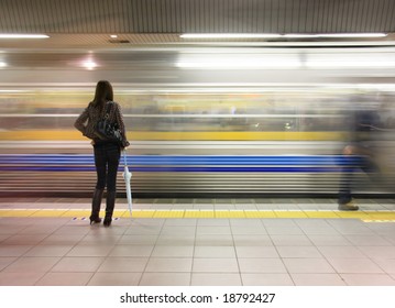 Lone woman watching subway speed by