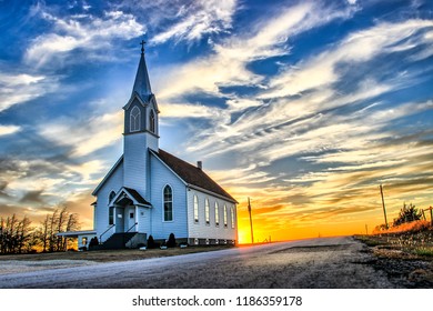 A Lone Wooden Church at Dusk with Sunset Clouds in Kansas American Midwest Prairie - Powered by Shutterstock