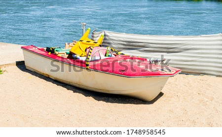 A lonely, abandoned boat on the sandy beach.