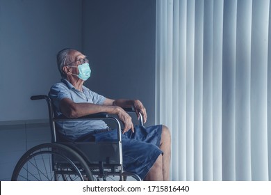 Lonely aged man wearing face mask sitting in a wheel chair alone looking at the window - Powered by Shutterstock