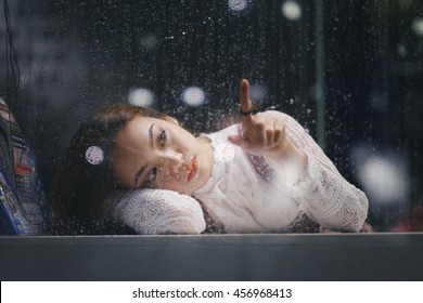 Lonely Asia Woman Near Window Thinking Something In Rainy Day