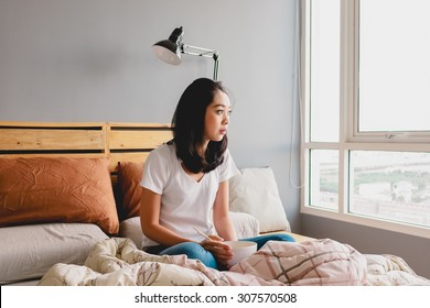 Lonely Asian Woman Is Eating Alone On Bed In Bright Morning.