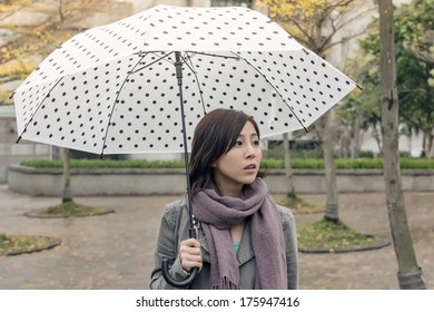 Lonely Asian Woman Holding An Umbrella In City.