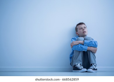 Lonely Autistic Child Sitting On A Floor In A Room