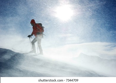 A Lonely Backcountry Skier Reaching The Summit Of The Mountain During A Snowstorm, Horizontal Orientation