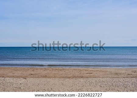 A lonely beach, blue sky, empty space. Horizontal, parallel, calm water, clean sand horizon horizontal