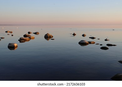 Lonely Beach With Boulders In Latvia In Summer, Low Tide, Calm Shallow Sea, Blue Hour Light Before Sunset