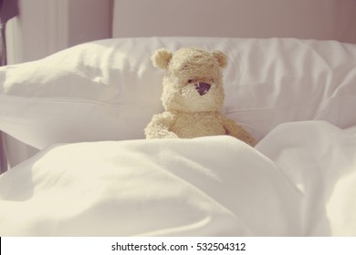 Lonely bear is  laying in bed. Idea for sick or lazy in bed in bedroom.