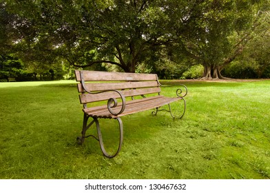 Lonely Bench On A Green Lawn. Sydney, Royal Botanic Garden