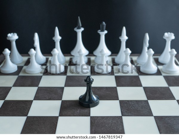 チェス盤の上に白い人影の全軍に一人で立っている寂しい黒いポーン ある人の軍隊を描いたコンセプト 有名なマーティン ルーサー キングのフレーズ 私には夢がある の写真素材 今すぐ編集