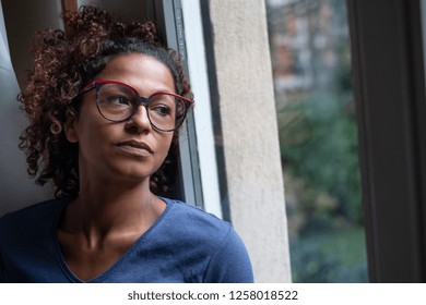 Lonely black woman near window thinking about something