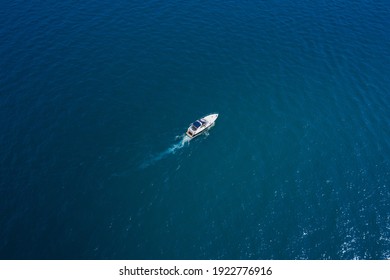 Lonely Boat On Blue Water. White Yacht Slow Motion On Blue Water, Boat Top View. Boat In The Sun.