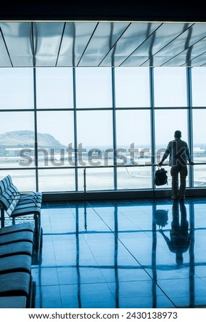 Lonely business man travel and wait at the airport gate - concept of delay and cancel filght problem and passenger rights - people move life and transport station