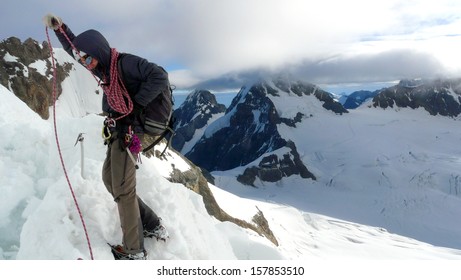 Lonely Climber Picking Up A Rope Over A Ridge While Climbing Jungfrau Moutain. Mönch And Eiger Summits Can Be Found Far Beyond, Switzerland 