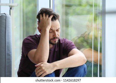 Lonely Depressed Man Near Window At Home