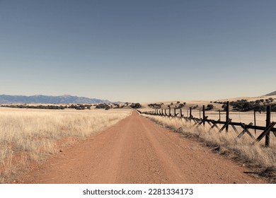 A lonely dirt road through the grasslands along the border between the United States and Mexico in Arizona.