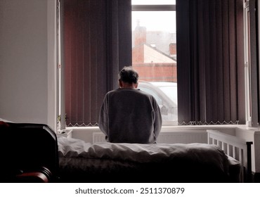 Lonely elderly man sitting by the window, reflecting on life - solitude and aging concept. - Powered by Shutterstock