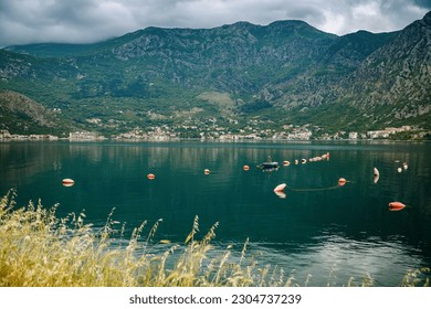 The lonely fisherman fishing in his boat along the beautiful coastline of Boka Kotor bay, Montenegro