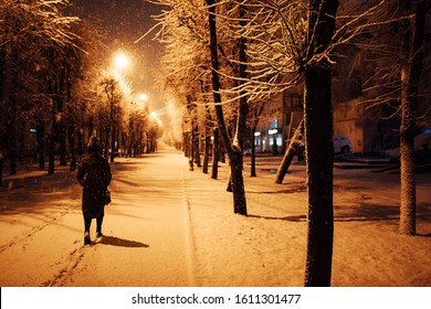 a lonely, frightened girl walks down a snow-covered street at night, in danger of being robbed and freezing