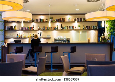 Lonely Girl Sits Alone At Modern Illuminated Hotel Bar