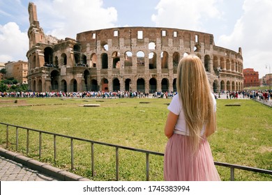 Lonely girl stands with her back to the camera and looks at the Roman Coliseum. Blonde in a white T-shirt and pink skirt dreams of traveling to Rome Italy - Shutterstock ID 1745383994