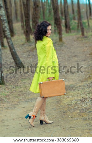 Lonely girl with suitcase at country road. girl with suitcase
