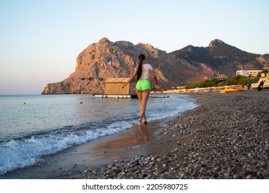 Lonely Girl Walking Along The Sea Along The Beach