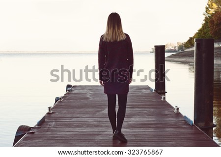 lonely girl walking on the pier. Free space for text. Copy space