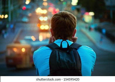 lonely guy sitting and looking at the lights of the evening city - Powered by Shutterstock