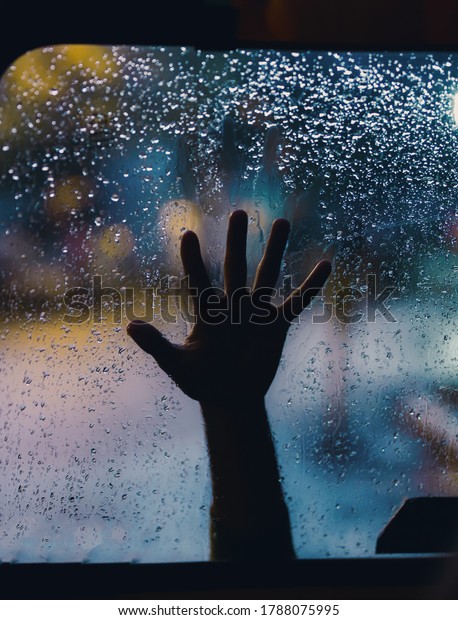 Lonely hand in the\
rainy droplets window