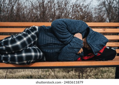 lonely homeless elderly old senior Caucasian man lying sleeping on a park bench in autumn - Powered by Shutterstock