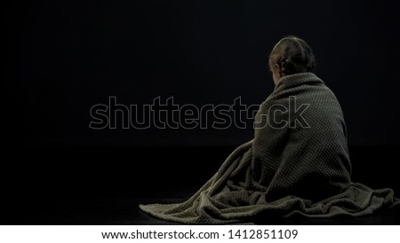 Lonely homeless kid in plaid sitting alone in dark place, orphan backview