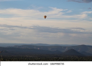 Lonely Hot Air Ballon Floating Over A Beautiful Desert Landscape.