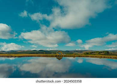 lonely house in the middle of the mountains of south america, and 
a beautiful landscape with sky reflected in the lake - Shutterstock ID 2024503358