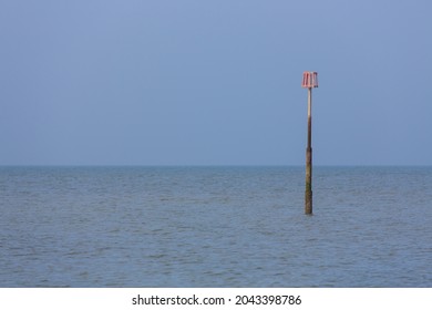 A Lonely And Isolated Tide Marker In A Blue Calm Sea