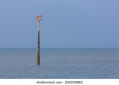 A Lonely And Isolated Tide Marker In A Blue Calm Sea