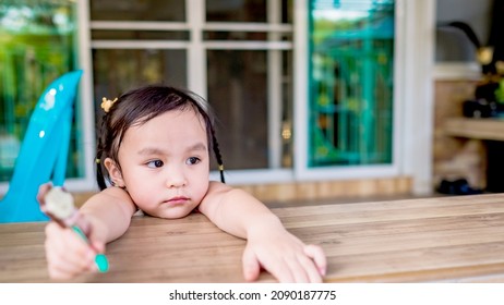 Lonely Kid Girl Standing Alone At Garden. Lonely Kid With Bored Face. Preschool Child With Unhappy Or Sad Face. Copy Space For Text.