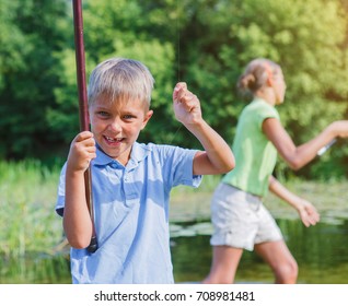 Lonely little boy with his sister fishing on river on the summer day - Shutterstock ID 708981481